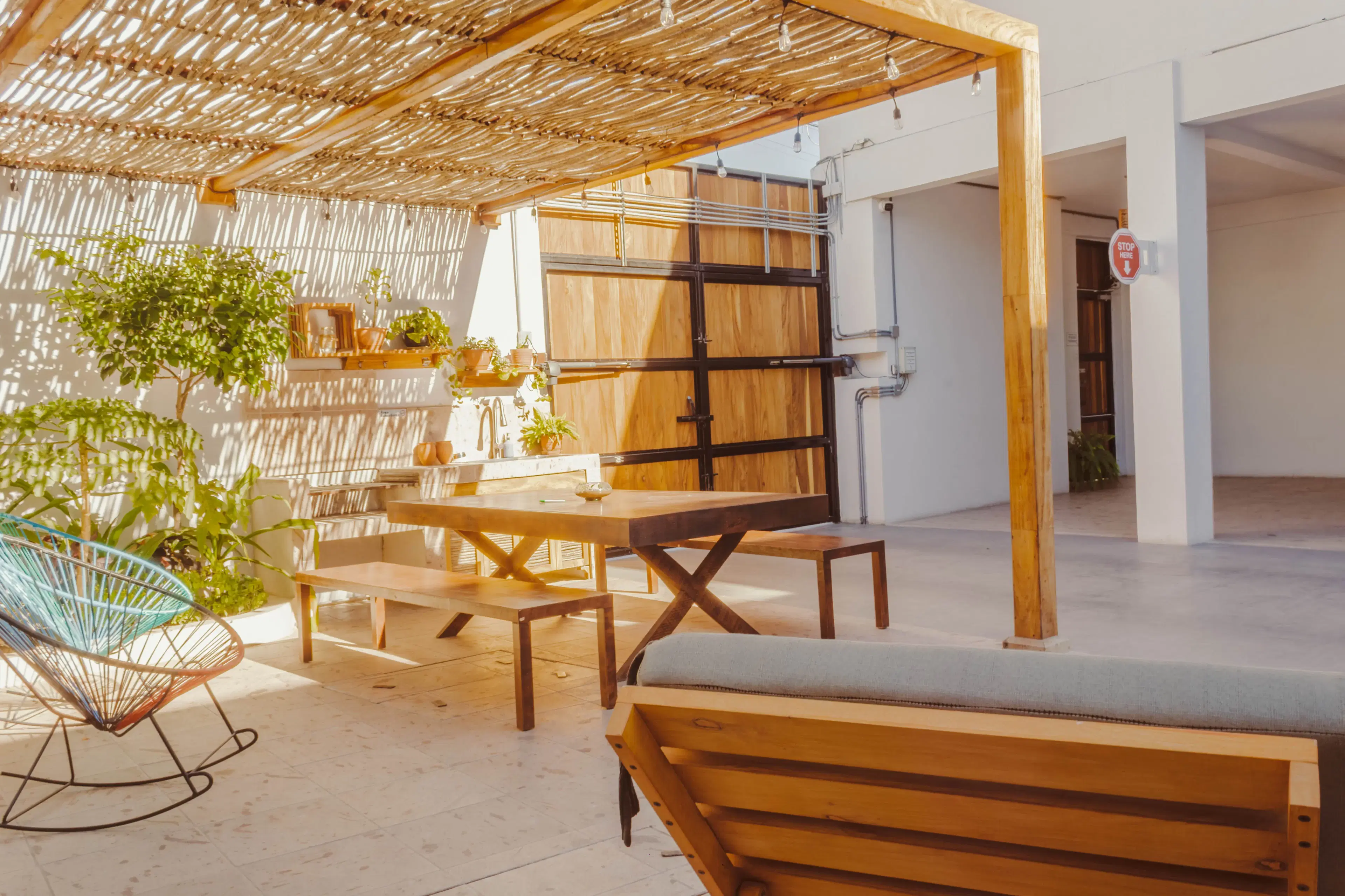 Outdoor lounge and dining space with string lights and kitchenette