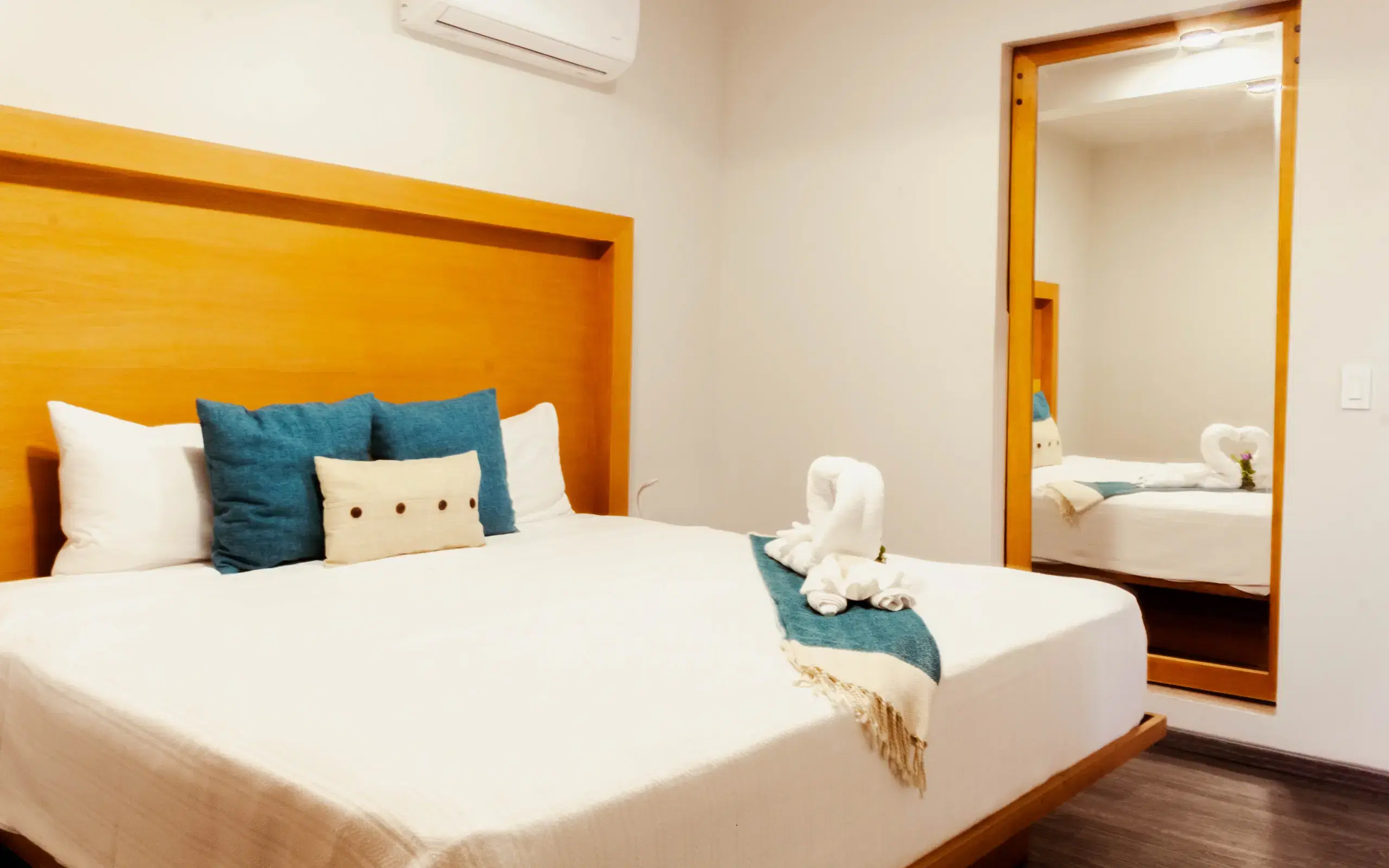 King Suite bedroom with wooden headboard and swan towel